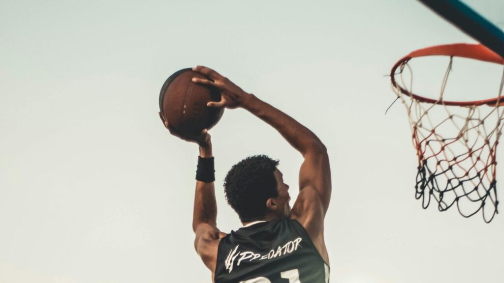 Content Marketing - coming soon A dynamic basketball player executing a slam dunk during a vibrant outdoor game.